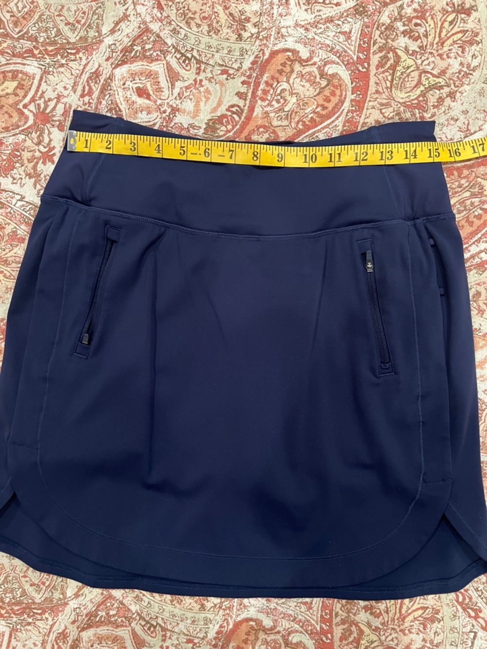 Athleta brand 18” navy blue "Fairway" golf skort with zip pockets.